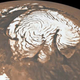 Illustration for article titled An ancient force that created the spiral ice chasms of Mars